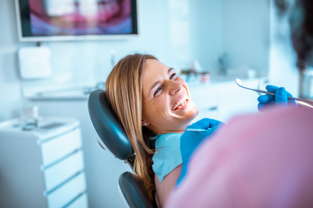 A woman smiling during a visit to the dentist’s office