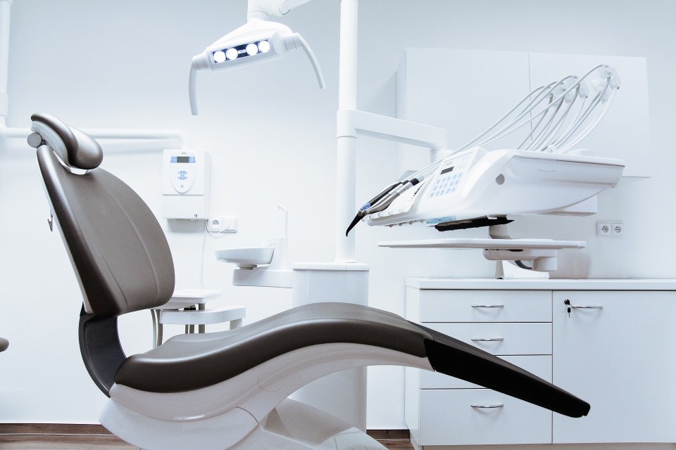 A dentist’s office with a chair and equipment