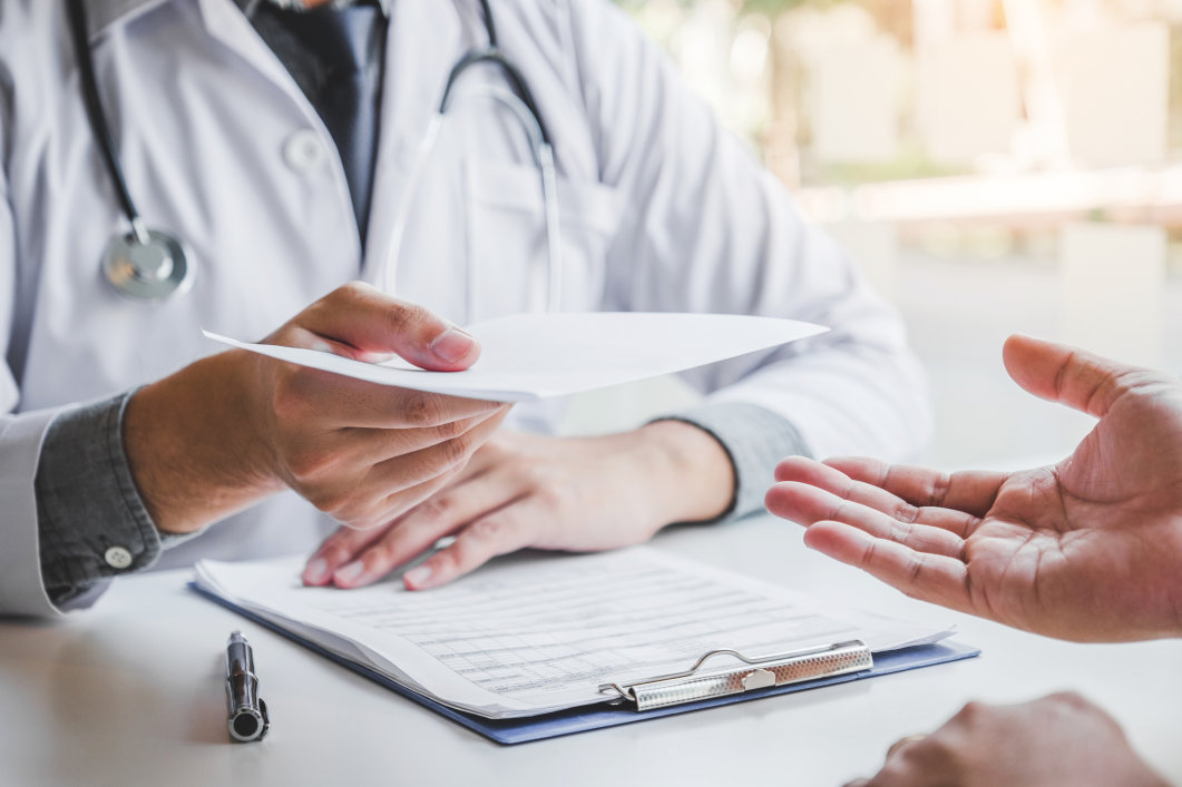 A male doctor handing a patient a medical prescription