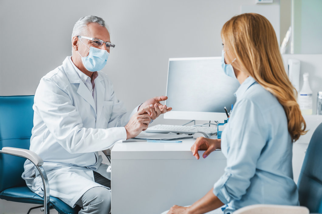 A male doctor talking during a consultation with a patient in his office.