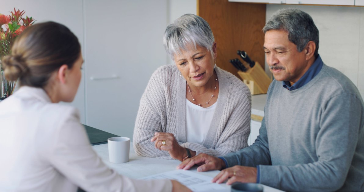 A mature man and woman reviewing a life insurance policy with an advisor