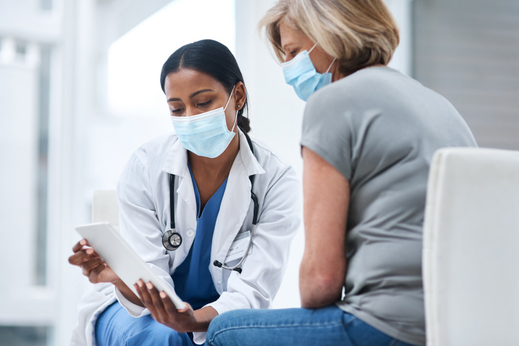 A female doctor showing information to an elderly female patient