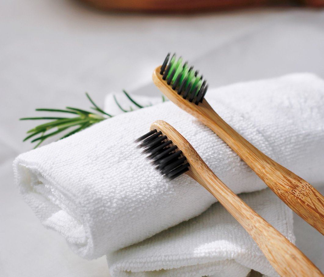 Two toothbrushes resting on folded white towels