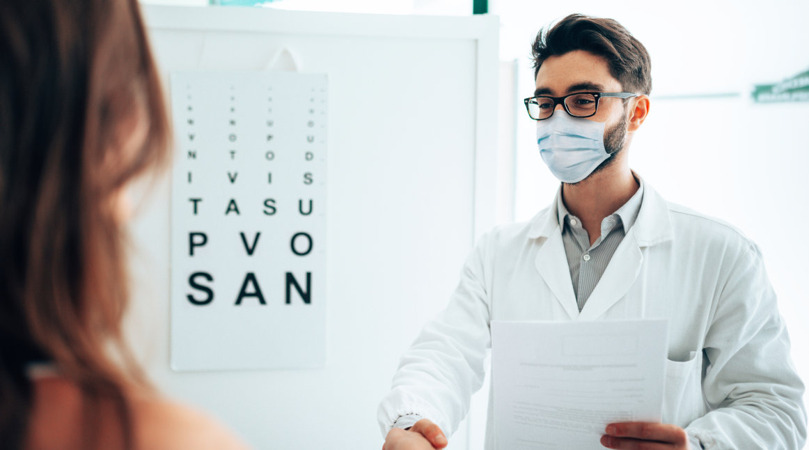 An optometrist greeting a new patient