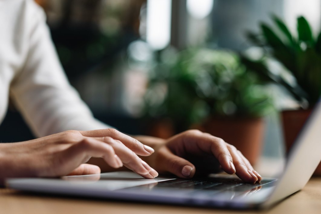 A closeup of a woman typing on her laptop