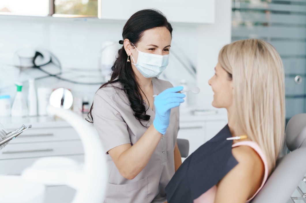 an orthodontist examines her patient's teeth