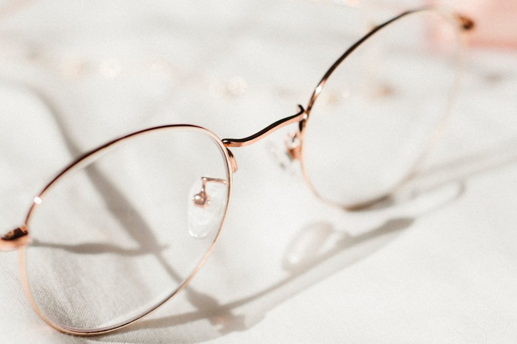 A closeup of a pair of glasses laying on a soft surface