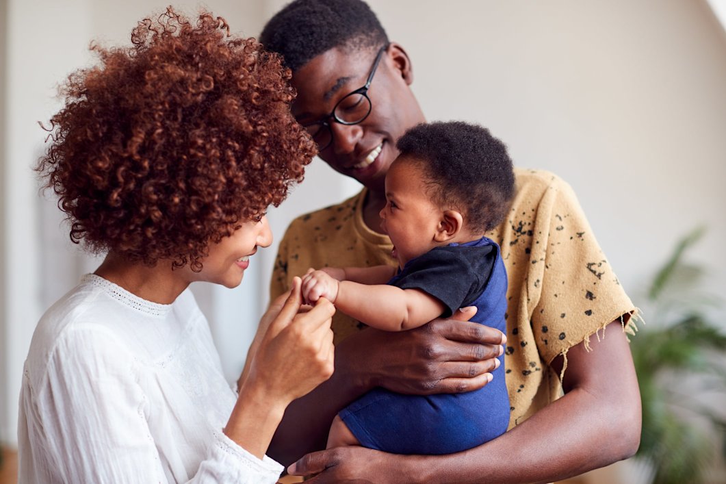 Two parents with their newborn baby at home