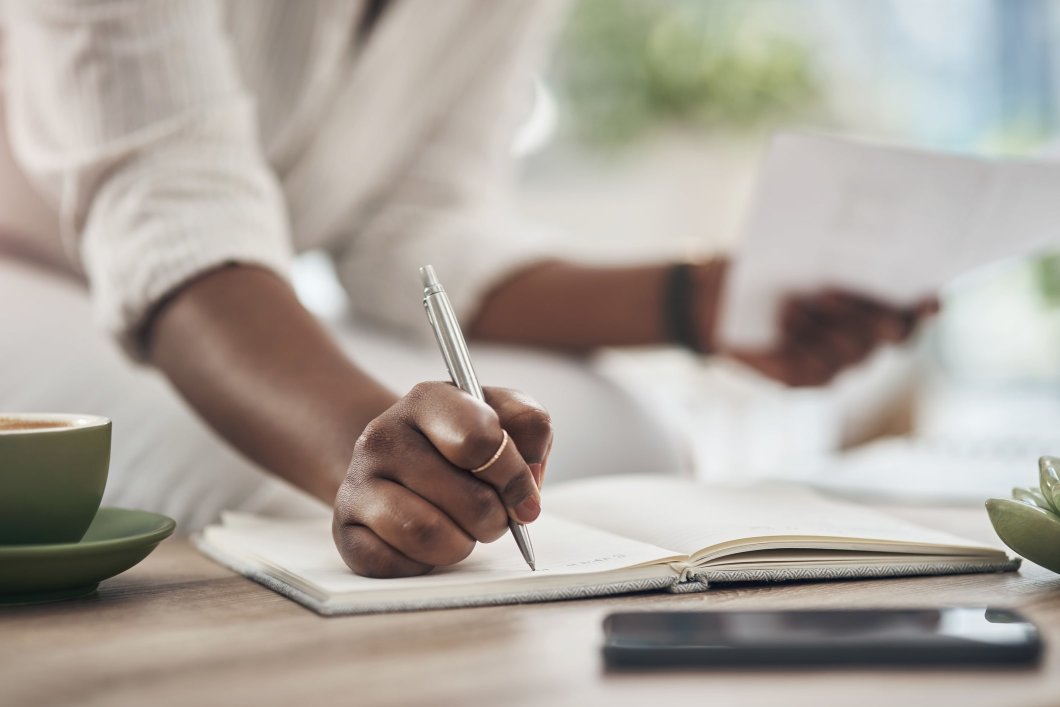 A woman writing in her notebook while reviewing trade credit insurance