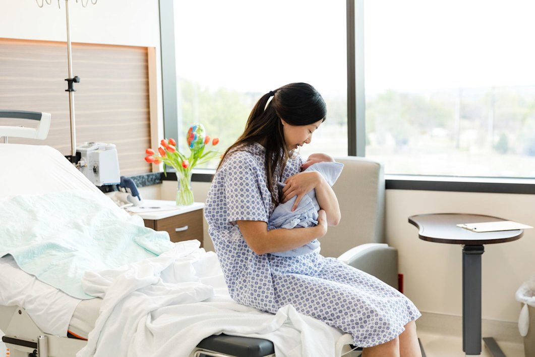 A mother holding her newborn in the hospital