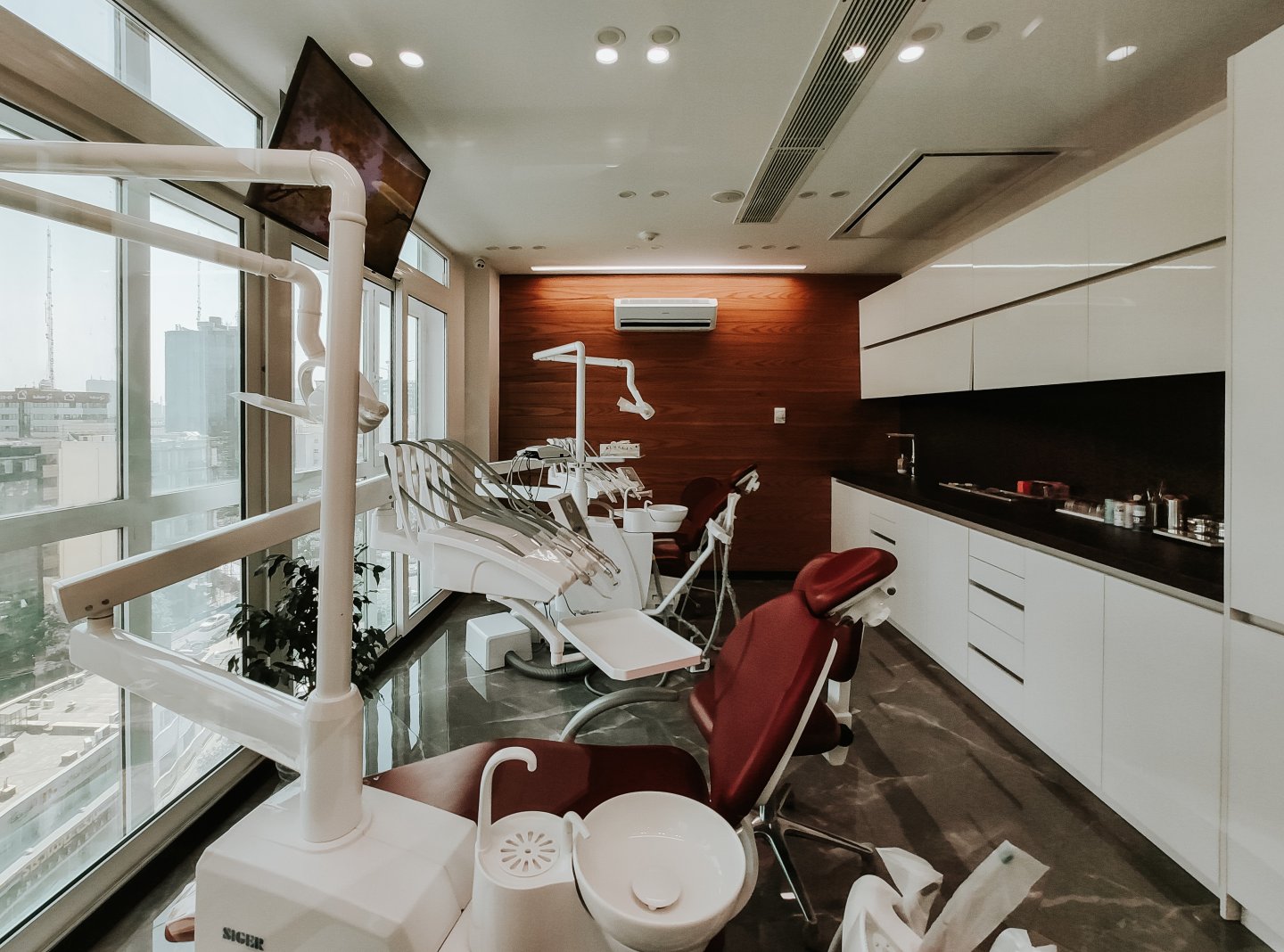 A dentist’s office with multiple chairs near a window