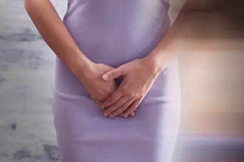 Una mujer tiene las manos sobre el bajo vientre porque sufre de mm