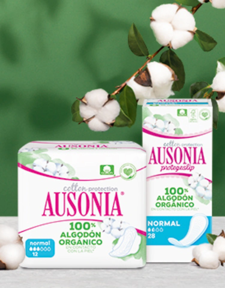 Dos paquetes: las compresas y protegeslips Ausonia Cotton Protection. Están rodeados de flores de algodón.