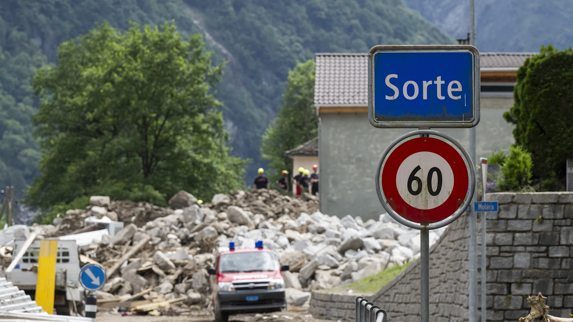 © KEYSTONE/Ti-Press/Alessandro Crinari Un cartello della città con la scritta Sorte. Sullo sfondo si vede la devastazione causata dalla tempesta.