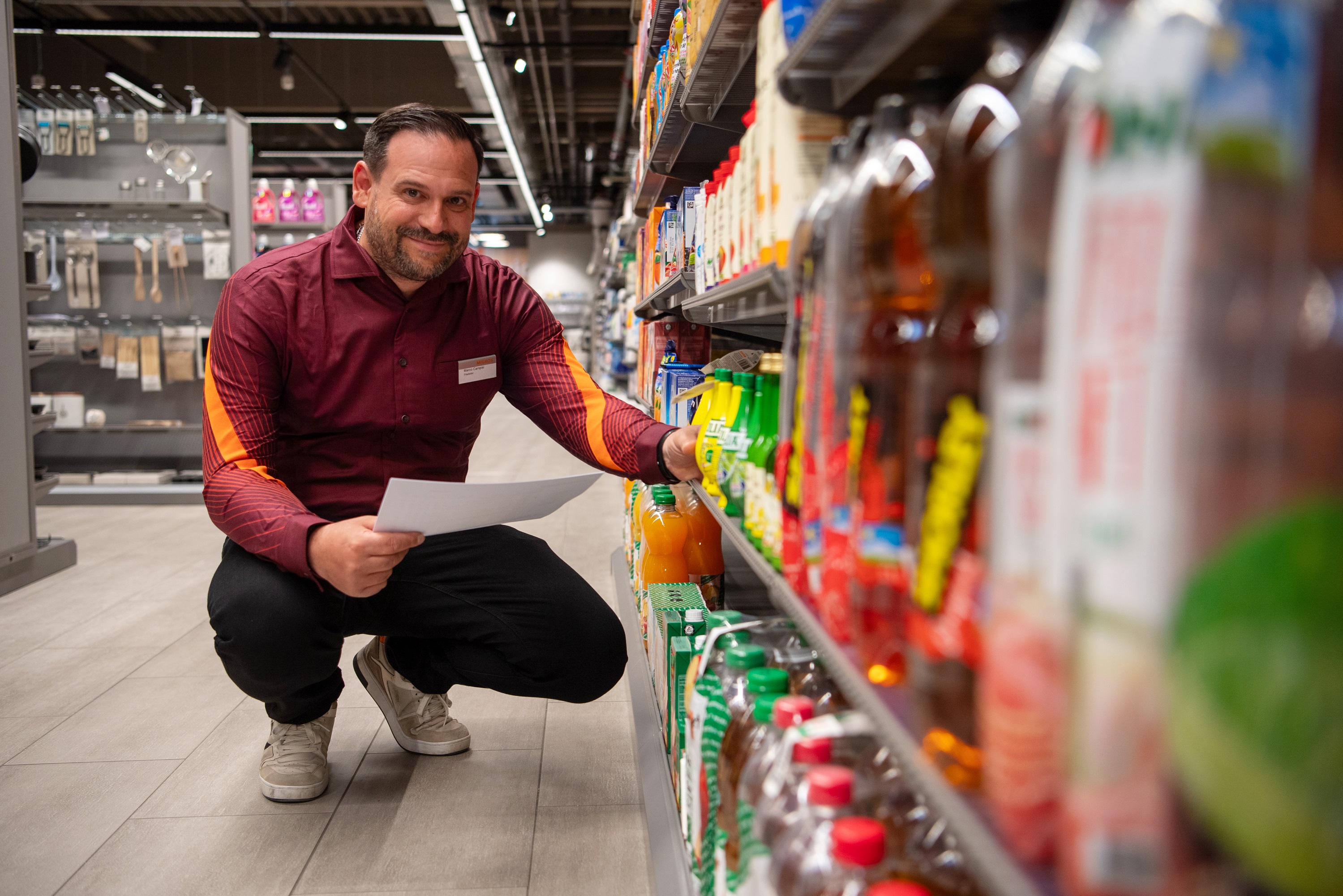 Filialleiter Marco Campisi beim Einräumen in der modernisierten Migros Pfungen