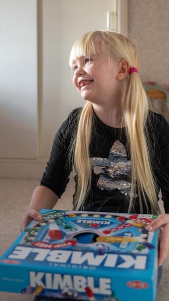 Elisa-tyttö pitelee Kimble-peliä. 