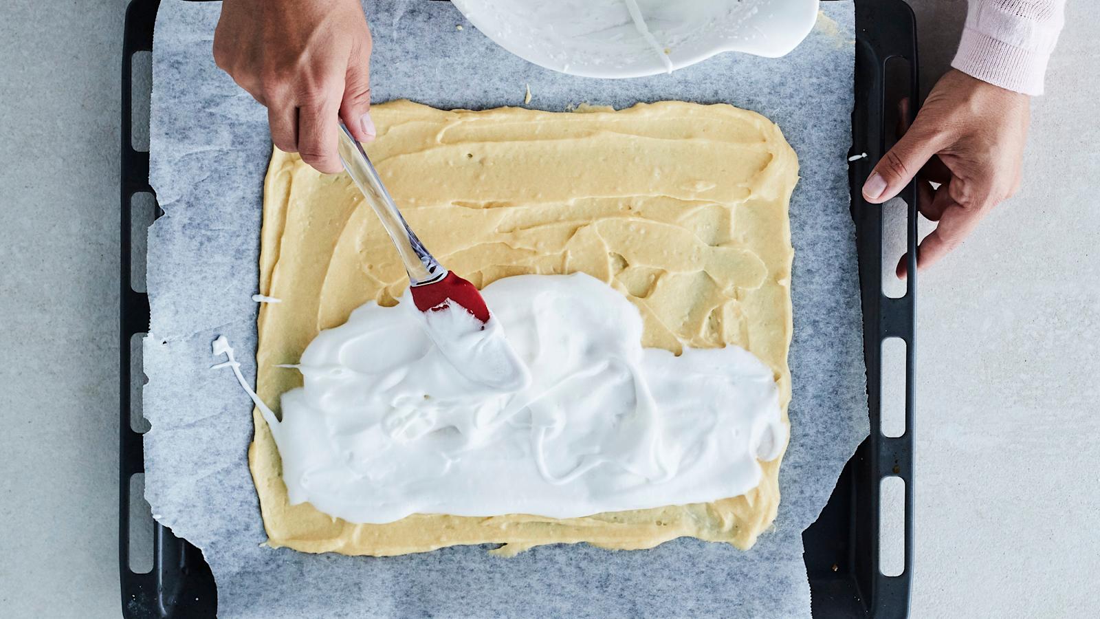 Levitä taikina leivinpaperille pellille 25 x 35 cm:n levyksi. Levitä marenki päälle ja ripottele pinnalle mantelilastut