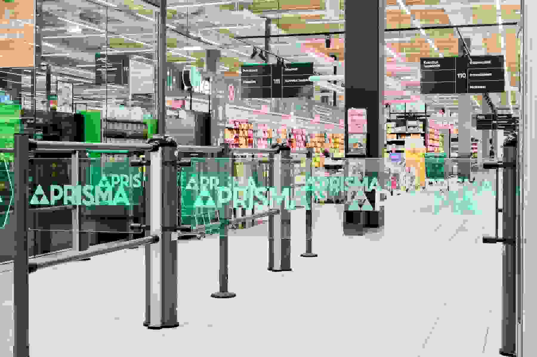 Kuva Prisman sisäänkäynniltä. Edessä vihreät Prisma-portit, joidenka takana näkyy myymälää mm. karkkiosastoa.