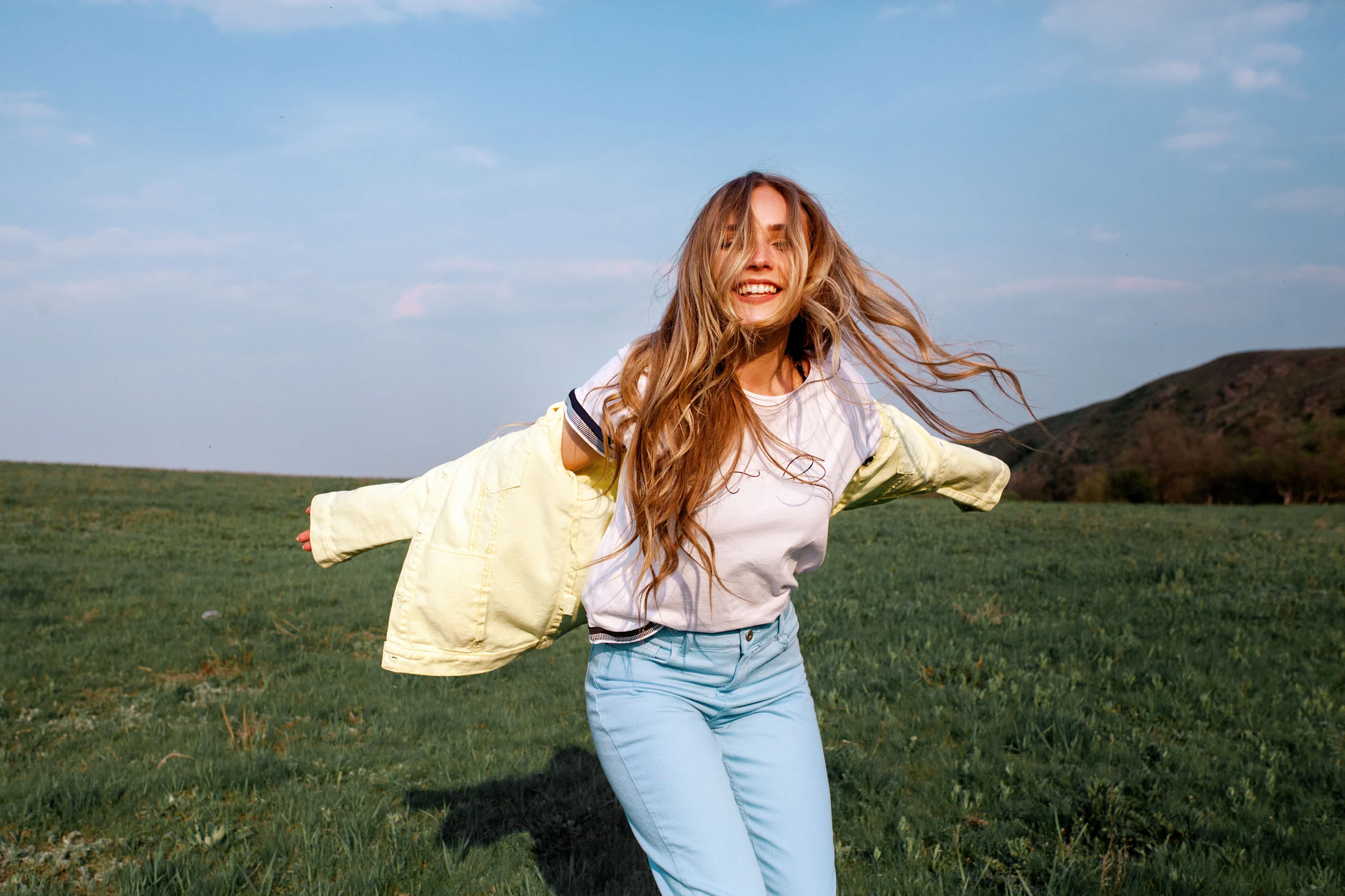 Ilonen nainen pellolla hiukset kasvoillaan