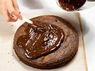 Kuumenna kerma kattilassa. Lisää joukkoon paloiteltu suklaa ja margariini. Sekoita, kunnes kuorrutus on tasaista. Anna hieman jäähtyä ja kuorruta kakku. Koristele ananaskirsikoilla.