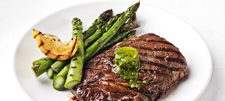 Grillattu vihreä parsa, entrecôte ja valkosipuliyrttivoi