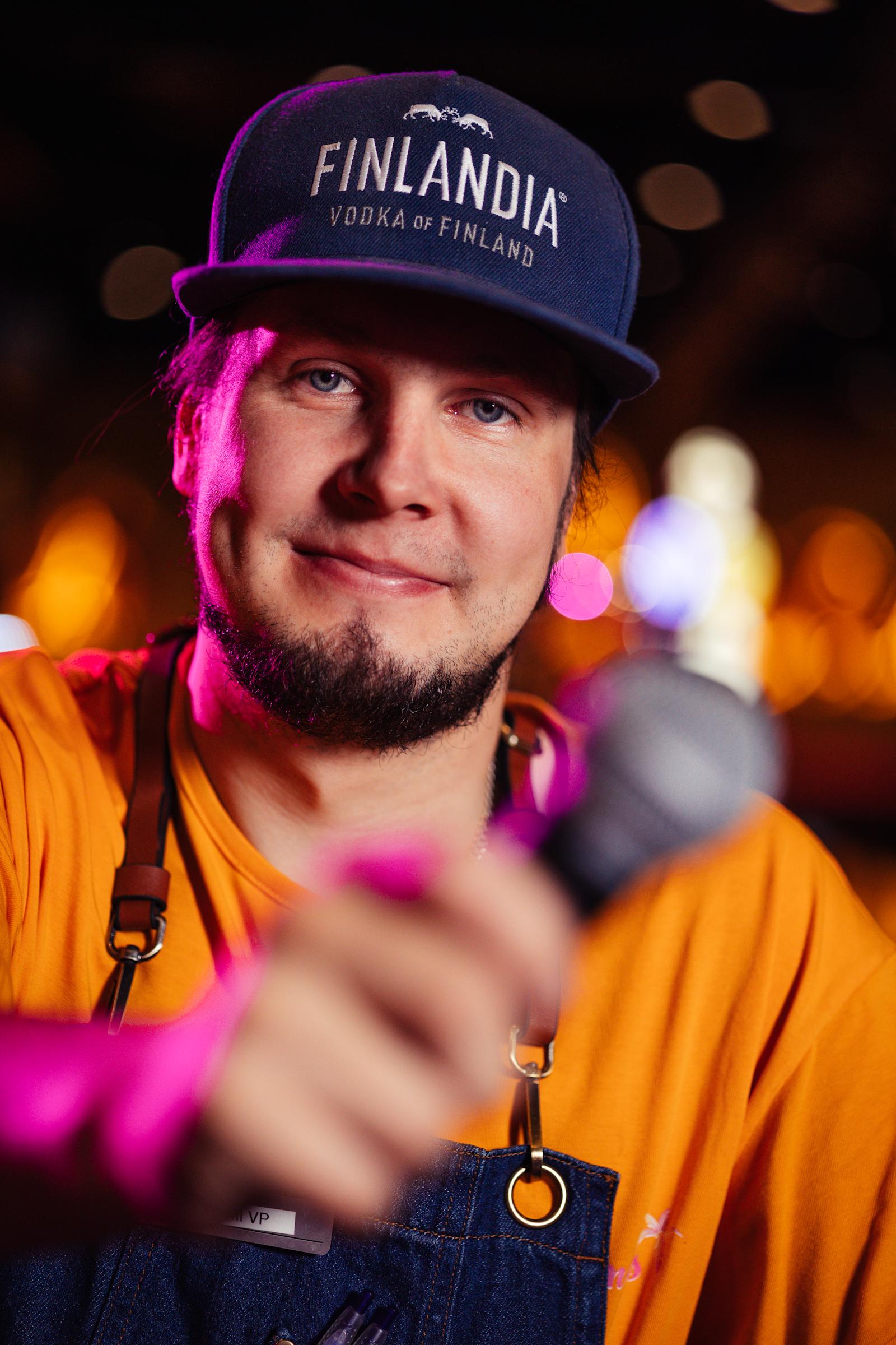 Karaokeisäntä Tomi Paakkunainen mikrofoni kädessä.