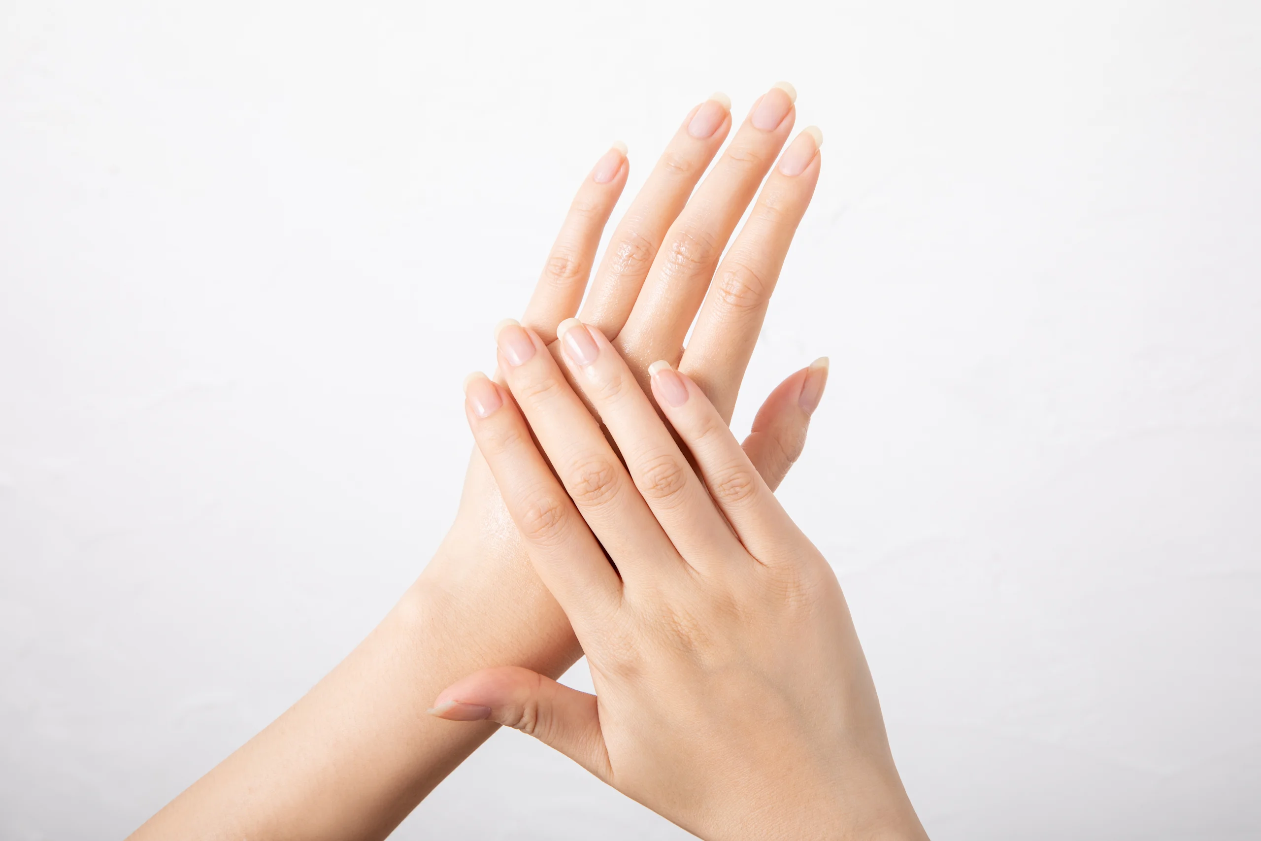 Naisen kädet valkoista taustaa vasten