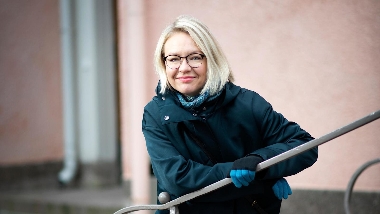 Maija Soljanlahti nojailee ulkoportaan kaiteeseen.