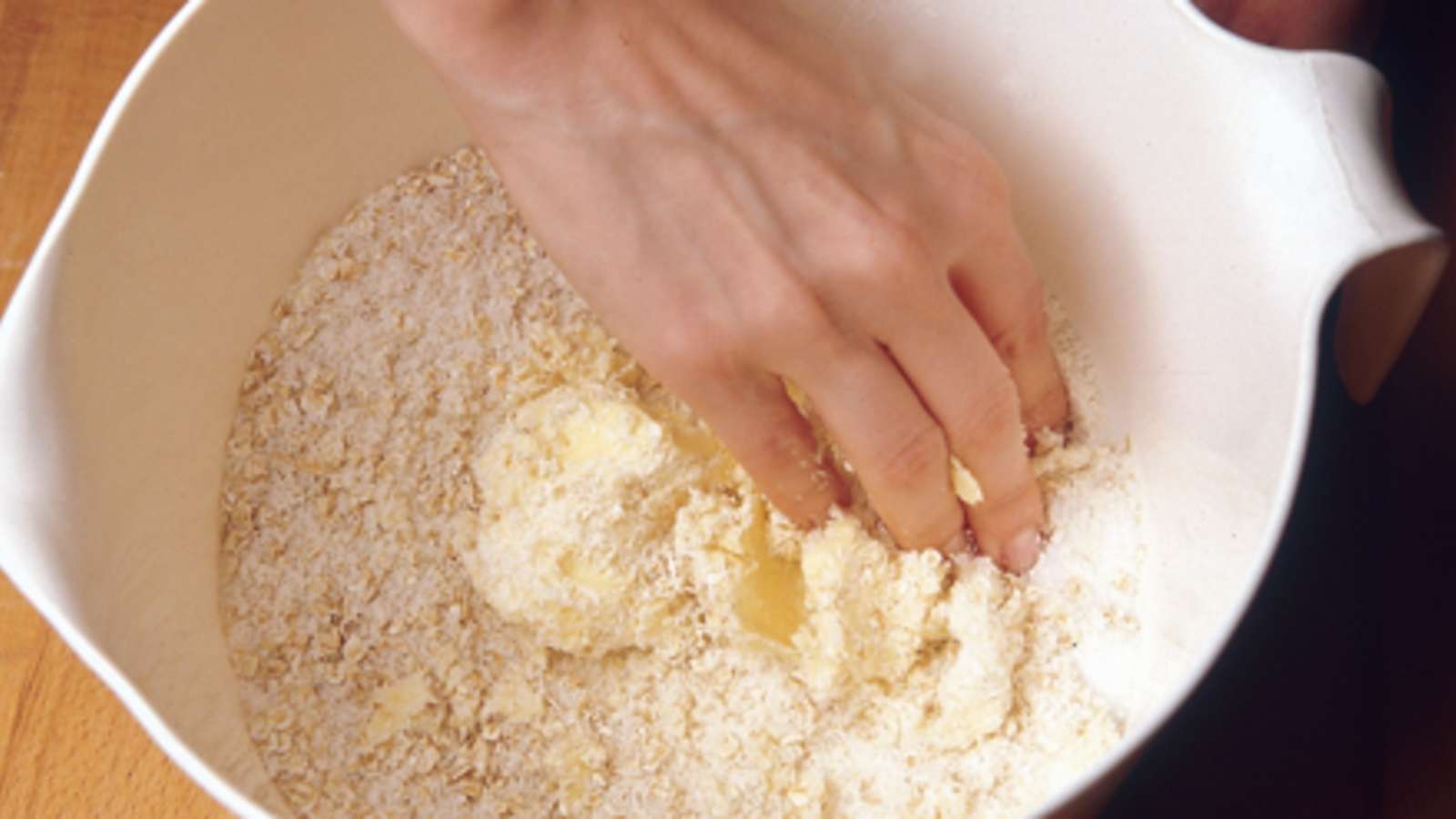 Valmista päällys. Nypi pehmeä rasva, hiutaleet, vehnäjauhot ja sokeri keskenään murumaiseksi seokseksi.