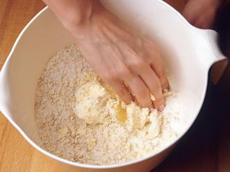 Valmista päällys. Nypi pehmeä rasva, hiutaleet, vehnäjauhot ja sokeri keskenään murumaiseksi seokseksi.