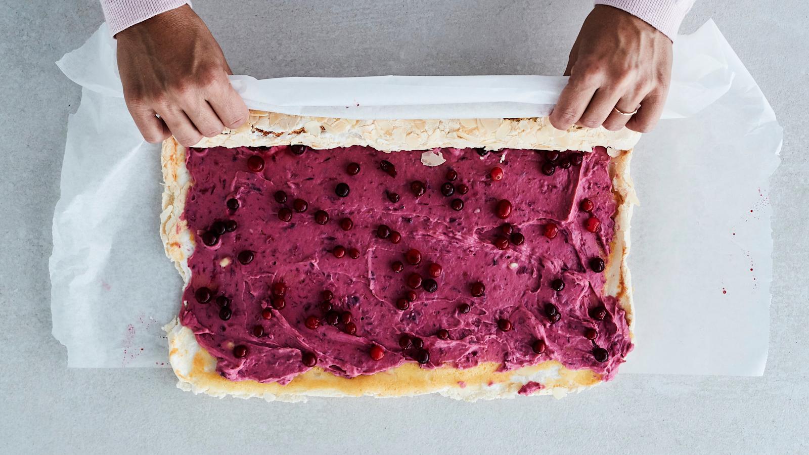  Kumoa pohjalevy varovasti leivinpaperin päälle. Levitä karpalokreemi levylle. Ripottele päälle reilu puolet karpaloista. Kääri rullalle