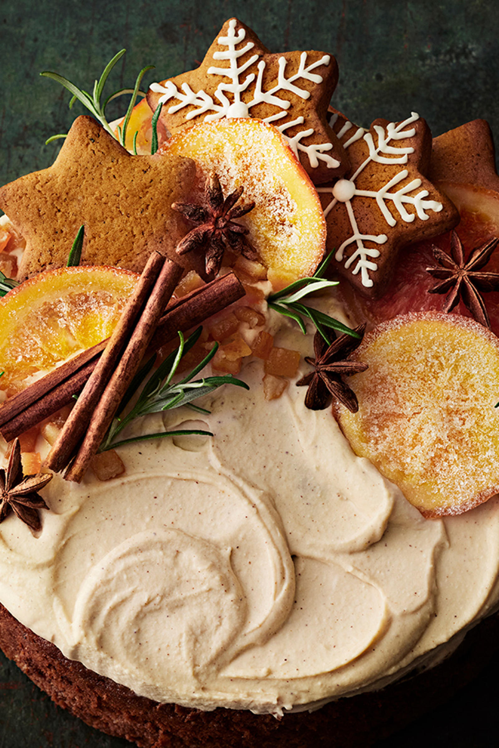 Englantilainen hedelmäkakku tuorejuustovaahdolla kuorrutettuna. Kakku on koristeltu kanelitangoilla, kandeeratuilla appelsiineilla, piparkakuilla, tähtianiksilla ja rosmariinitupsuilla.