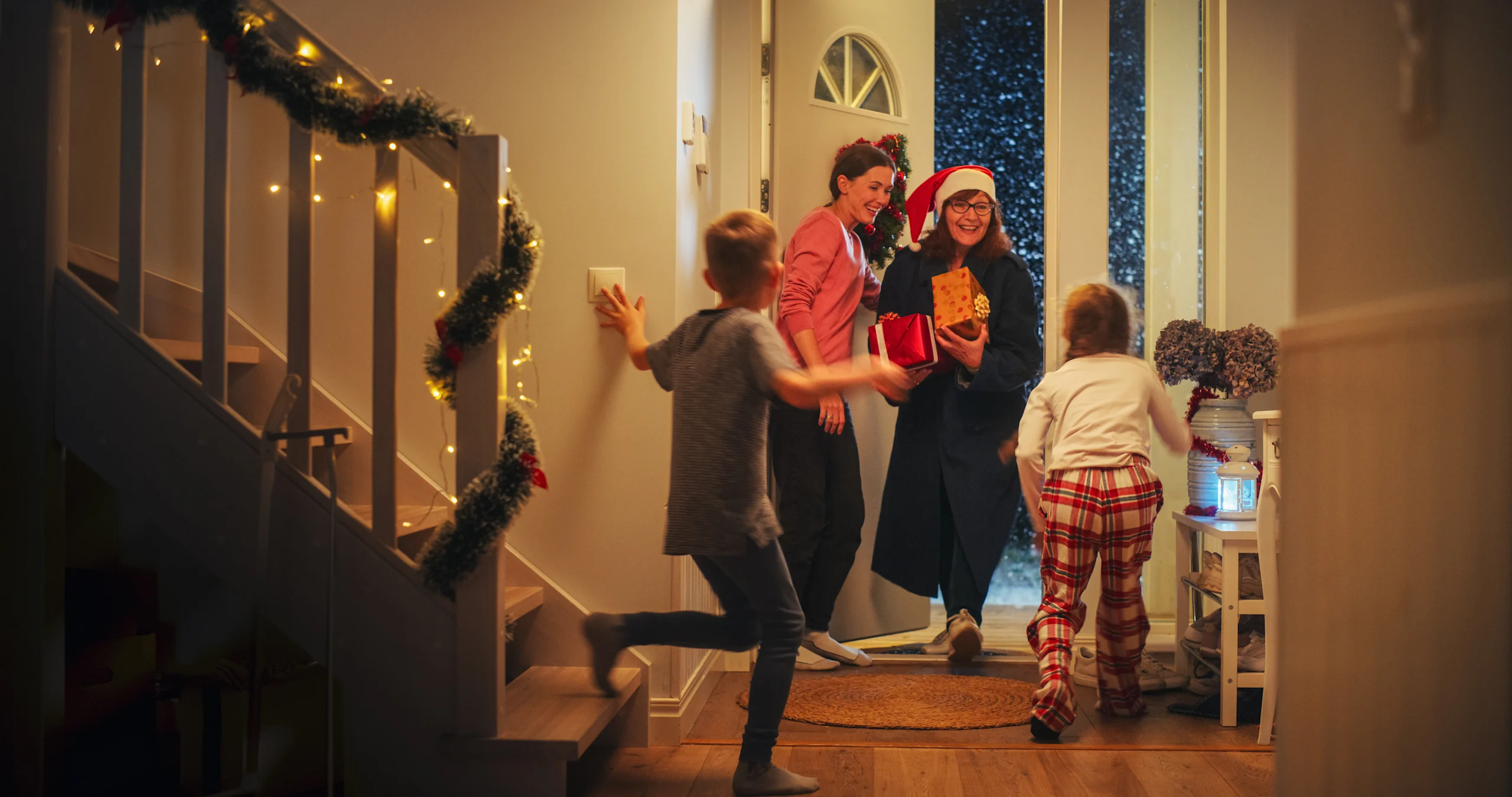 Perhe vastaanottaa vieraita ovella joulunaikaan