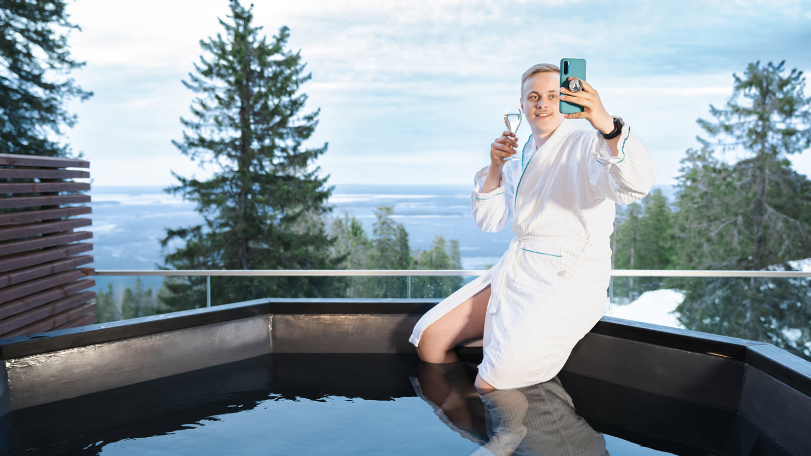 Nuori mies ottaa selfietä Kolin Break Sokos hotellin ulkopaljun reunalla. 