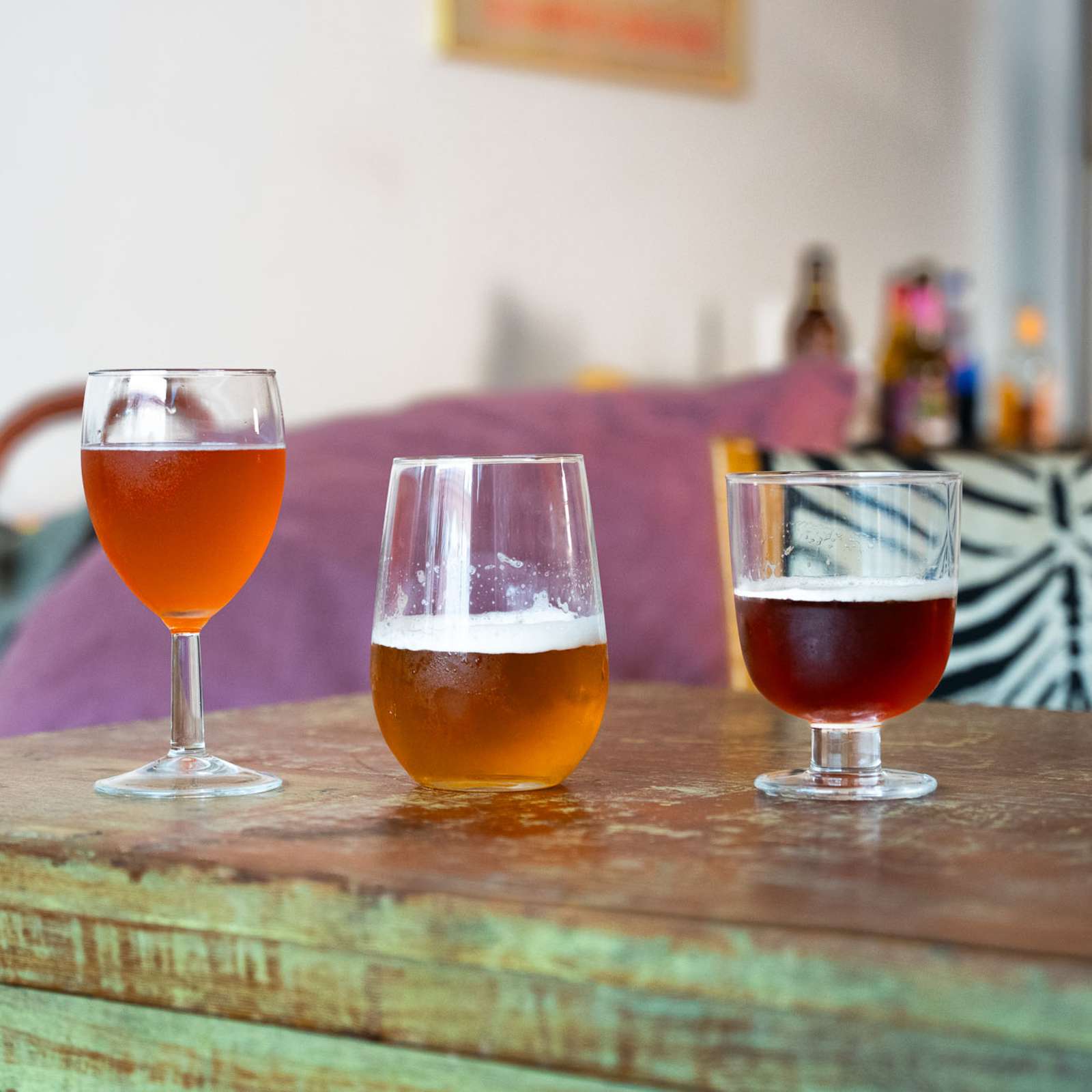 Viisi olutlasia rivissä pöydällä. Jokaisessa lasissa on eri olutta.