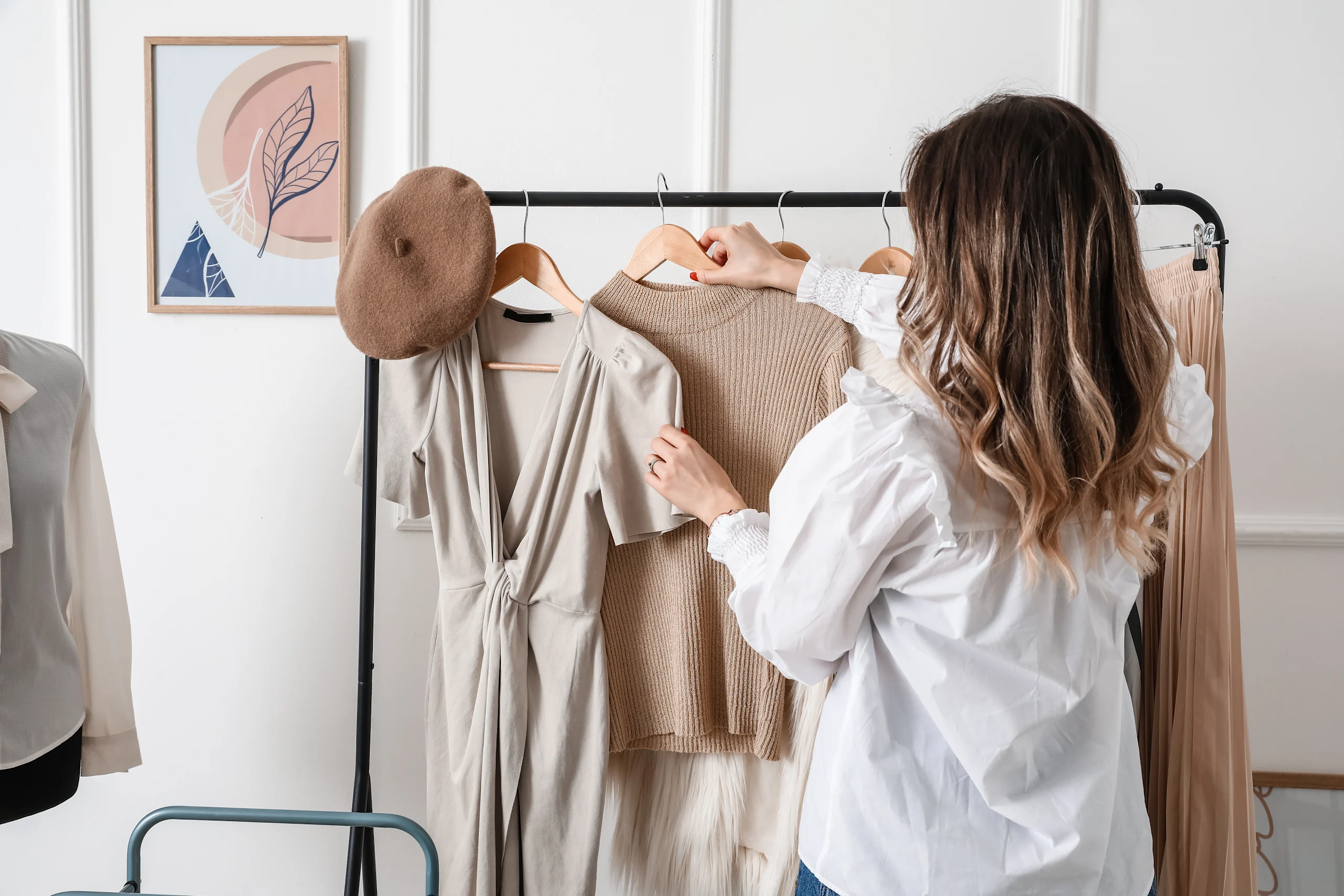 Nainen ottaa vaaterekistä beigen paidan