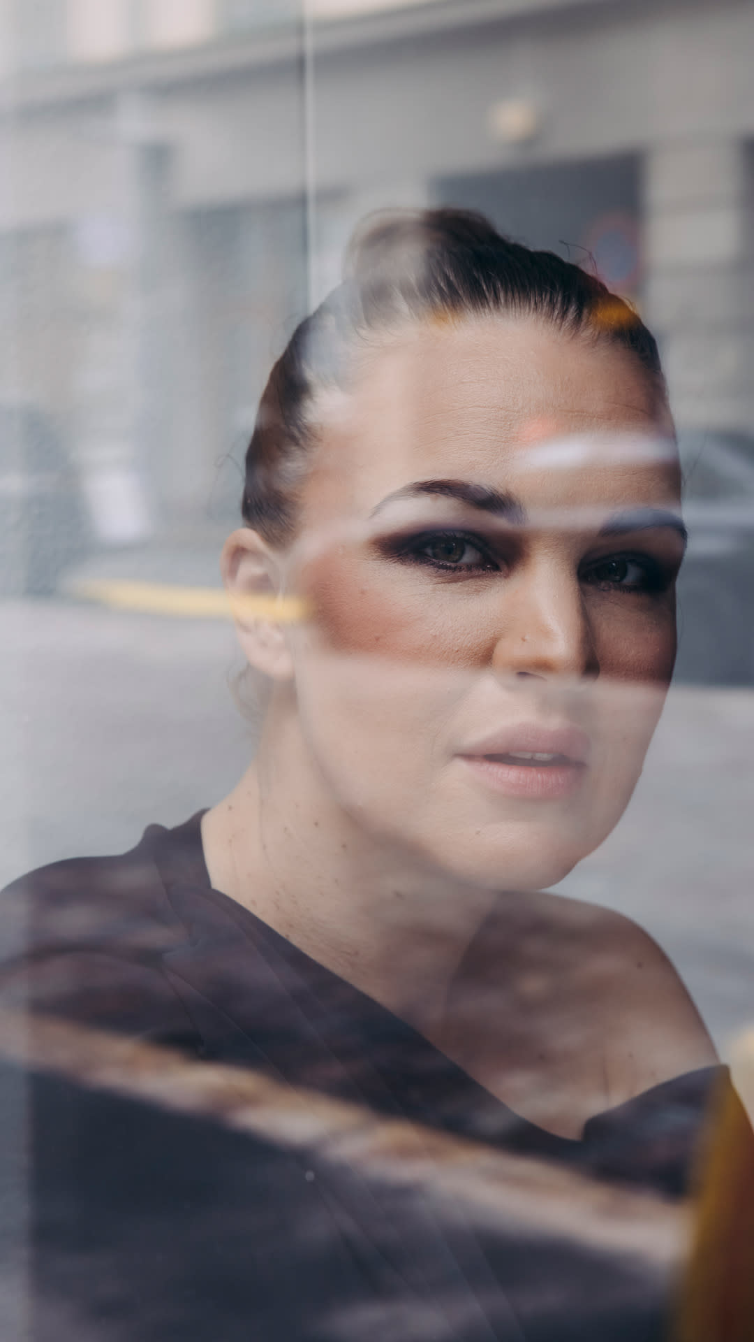Katri Niskanen lähikuvassa ikkunalasin läpi kuvattuna.
