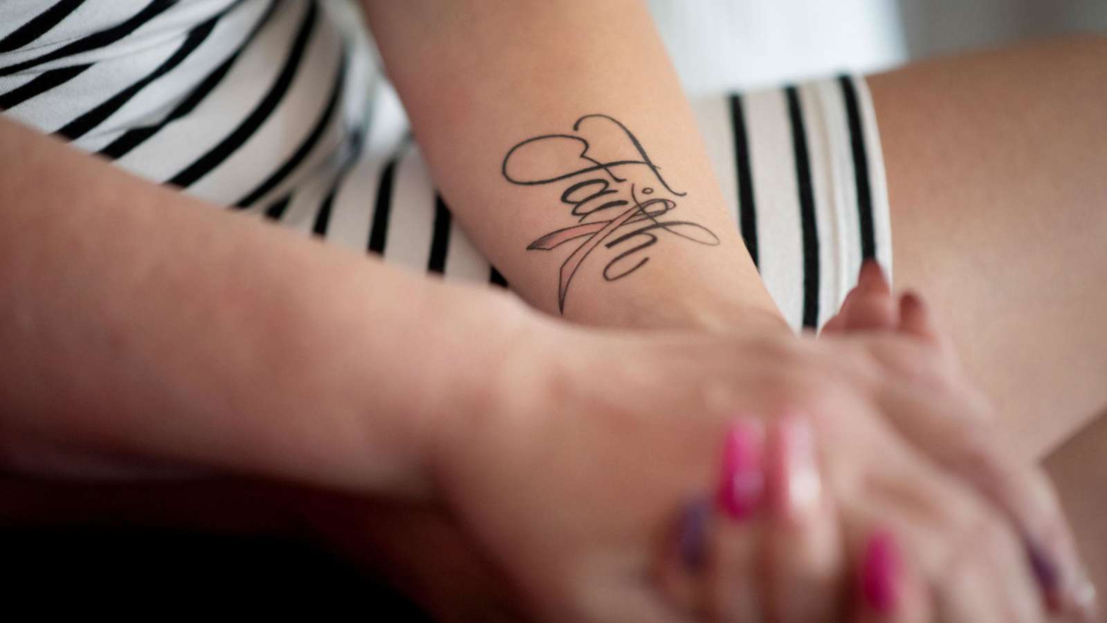 Tiitulotta Villmanin käsivarressa on tatuointi Faith, usko.