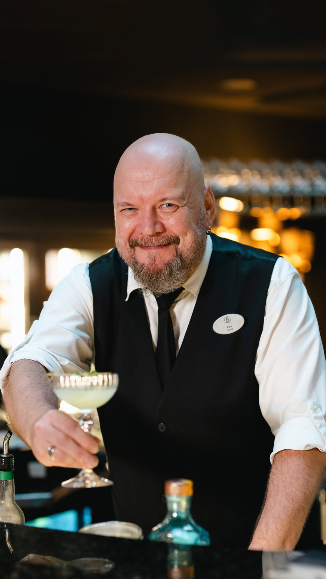 Solo Sokos Hotel Tornin American Barin baari-isäntä Esa Paloharju tarjoaa hymyillen drinkkiä.