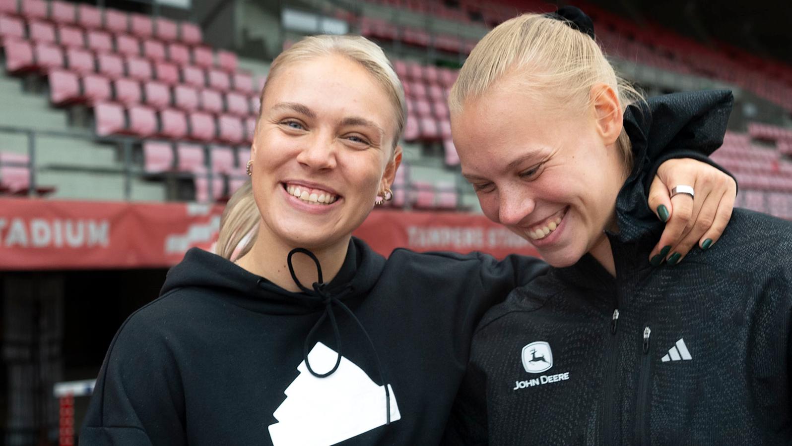 Yleisurheilijat Vilma Itälinna ja Saga Vanninen yhteiskuvassa. Vilman käsi on Sagan hartioilla. Molemmat nauravat.