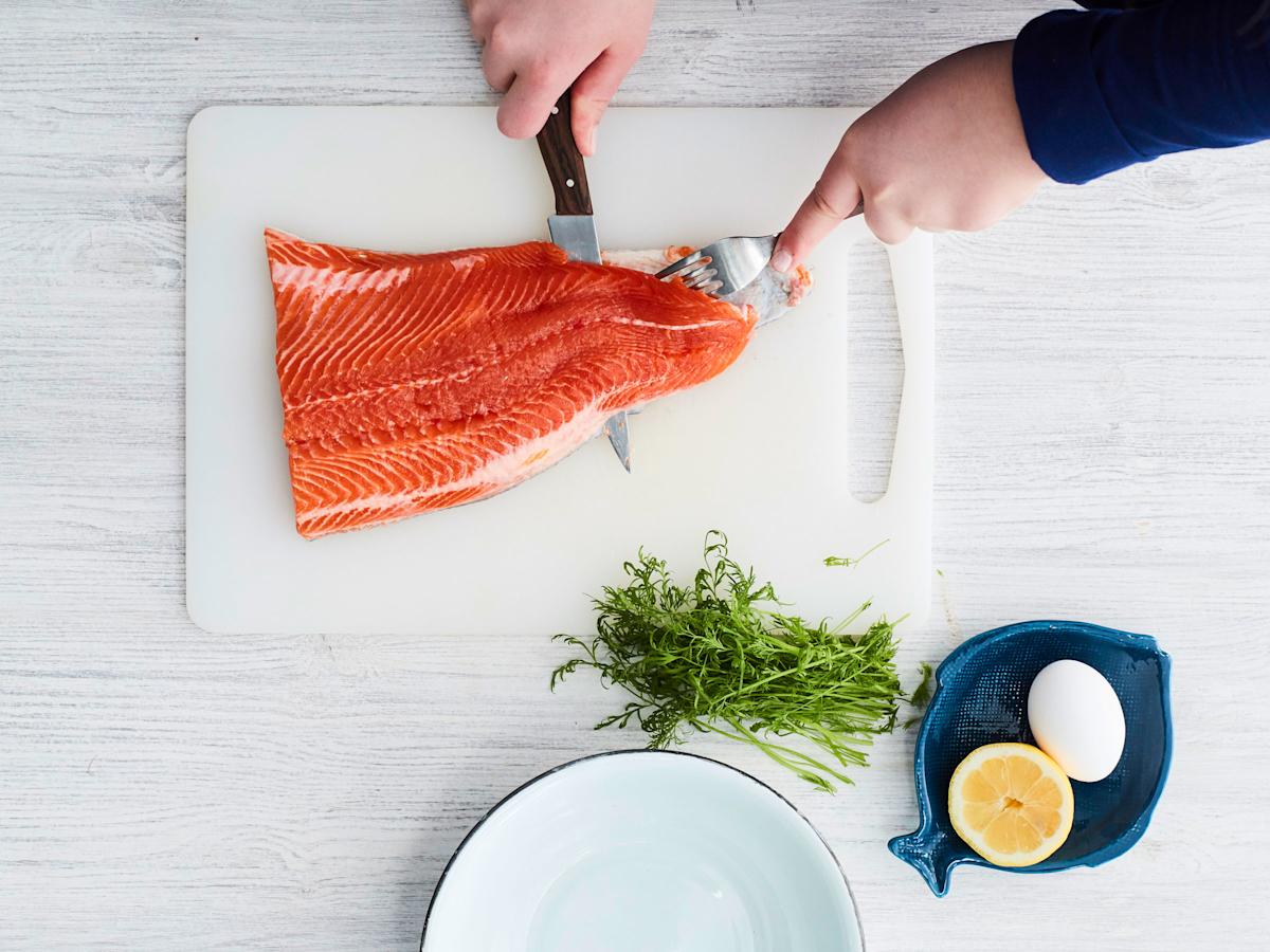 Laita lohifilee leikkuulaudalla nahkapuoli alaspäin. Pidä haarukalla lujasti kiinni fileen kapeasta päästä.