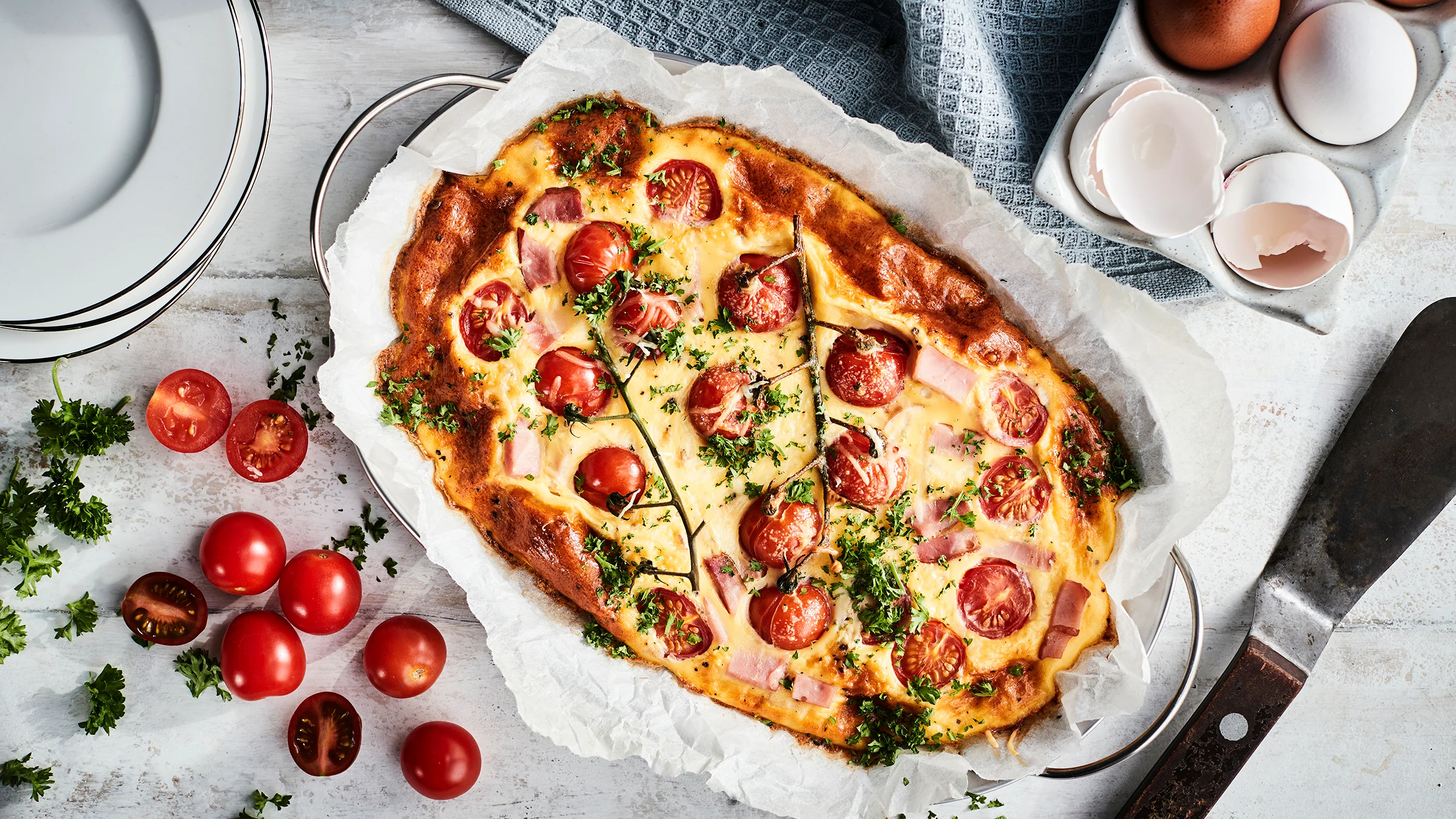 Uunimunakas kinkulla ja tomaateilla