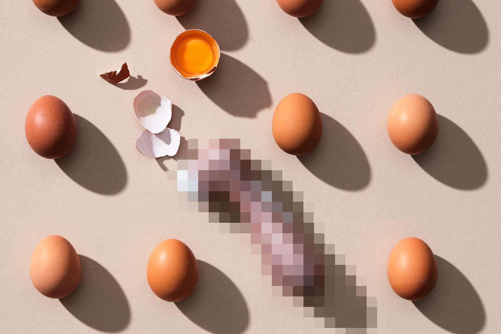 Raakoja kananmunia, joiden keskellä sumennettu seksilelu