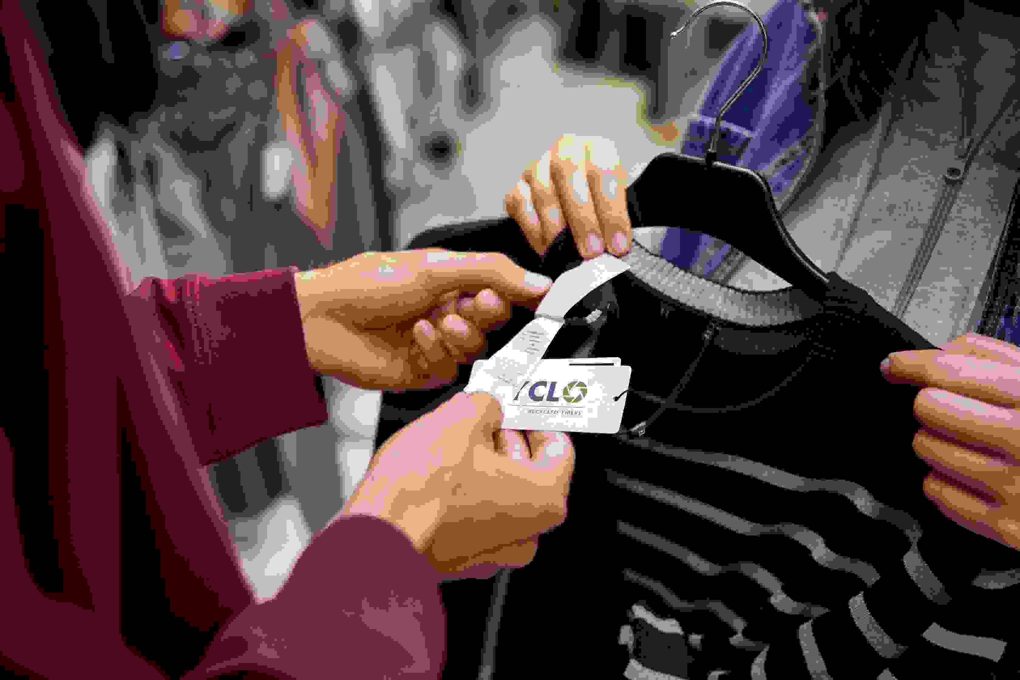 Myymälässä asiakas pitää kädessään tuotteessa riippuvaa Cyclo-merkkiä