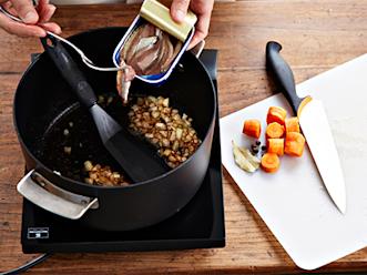 Kuori ja paloittele sipuli. Lisää kasariin anjovisfileiden, siirapin ja etikan kanssa. Kuullota ne. Lisää joukkoon mausteet, kuorittu ja paloiteltu porkkana sekä vesi. Kiehauta.