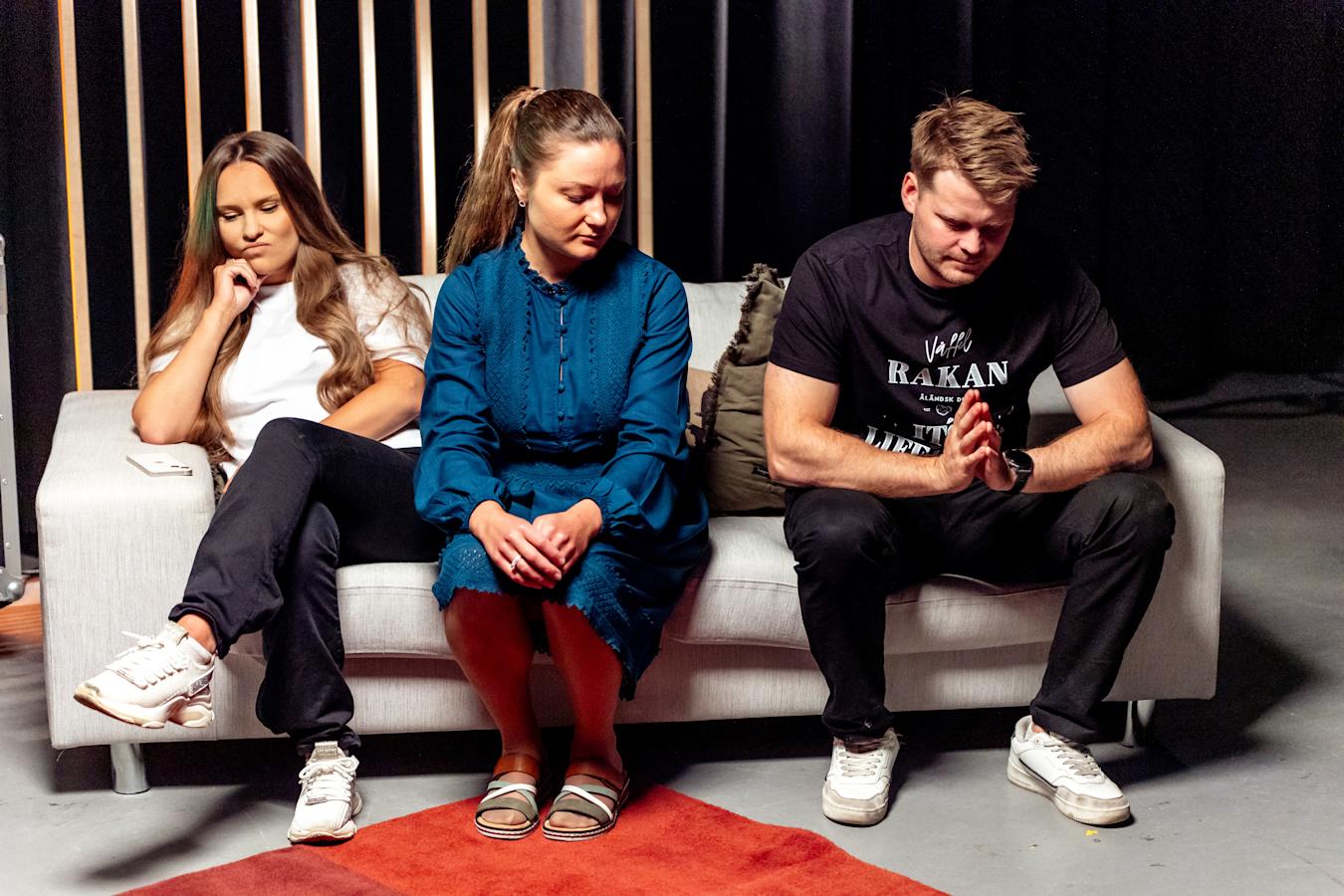 Emilia Karttunen, Silpa Kinnunen ja Jack Mattsson istuvat mietteliään näköisenä sohvalla.