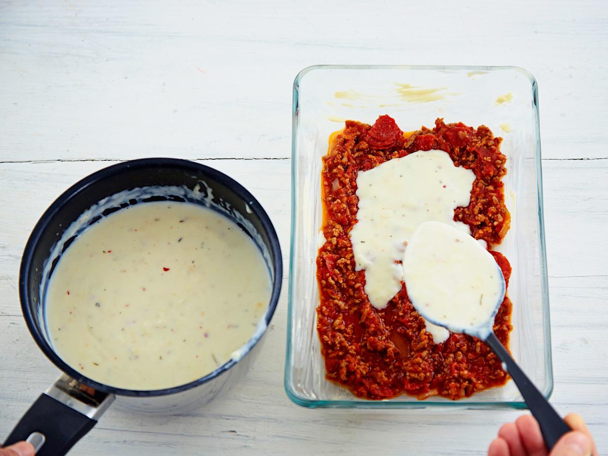 Nostele lasagnevuoan pohjalle 1/4 jauhelihakastiketta ja 1/4 juustokastiketta.