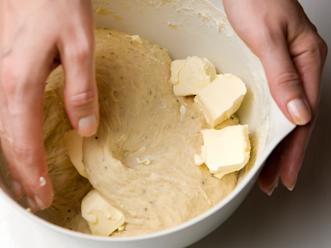 Lisää suurin osa jauhoista ja vaivaa 5 minuuttia. Lisää loput jauhot ja vaivaa vielä muutama minuutti. Lisää taikinaan pehmeä margariini ja alusta se hyvin taikinaan. Lisää tarvittaessa jauhoja.