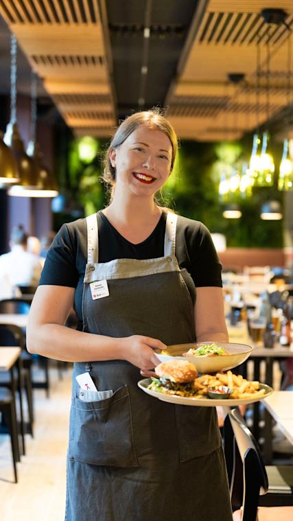 Ravintolatoimen päällikkö Sanna Summala tarjoilee ruokaa