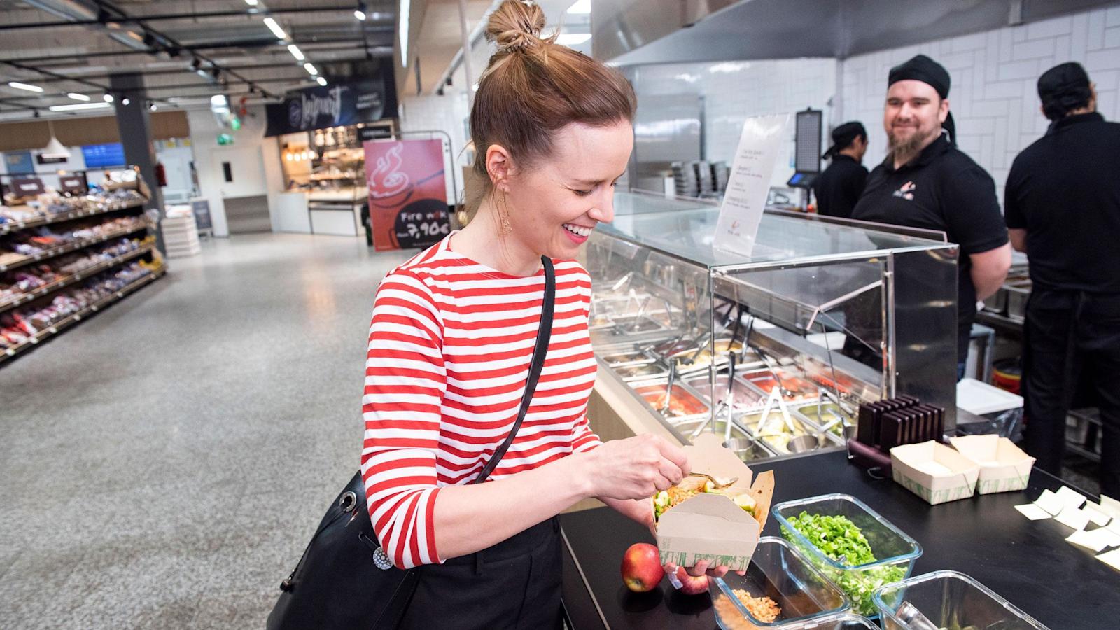 Essi Kärpijoki maustaa wokkiannostaan uuden konseptin mukaisessa S-market Manhattanissa Turussa. Taustalla ravintolatyöntekijä Tuukka Reivo. 